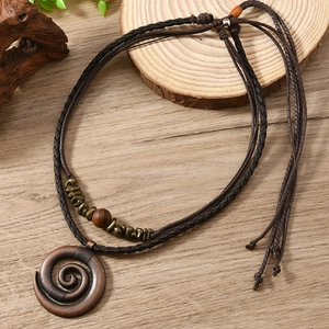 Close-up of bohemian leather necklace with spiral metal pendant and wooden beads