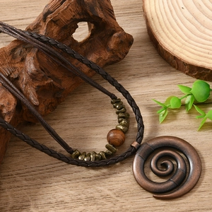 Bohemian leather necklace featuring a bronze spiral pendant and vintage wooden beads