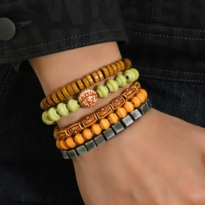 Detailed view of layered bohemian beaded bracelets with wood and resin beads on wrist