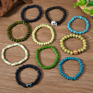 Bohemian handmade beaded bracelets with skull charms and evil eye on wooden background