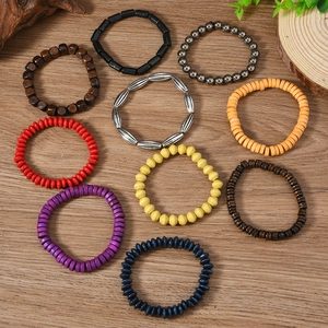 Flat lay of bohemian wood bead bracelets set with various colors on wooden background