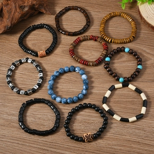 Détail d'un lot de 10 bracelets bohèmes en perles de bois sur surface en bois rustique
