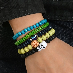 Bohemian beaded bracelet set with skull charm and evil eye beads on denim background