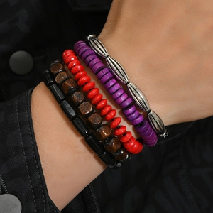 Close-up of bohemian stacked bracelets with wood and metal beads worn on wrist