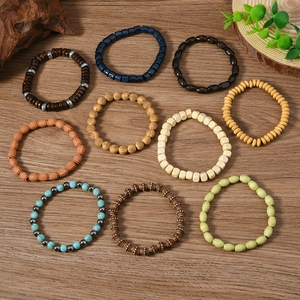Vue détaillée à plat de bracelets bohèmes en perles aux formes variées sur fond en bois