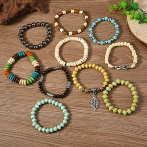 Flat lay of 10-piece Bohemian mixed-color beaded bracelets with leaf pendant on wood