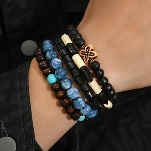 Gros plan de bracelets de perles en bois pour hommes avec turquoise et pendentif en croix