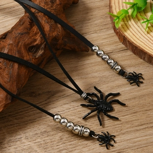 Punk gothic black spider pendant necklace with silver beads on a natural wooden background