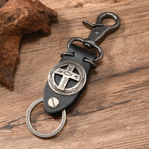 Macro view of vintage leather keychain with cross emblem and metallic swivel clasp