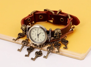 Macro view of vintage brown leather strap with bronze skull and hanging key charms