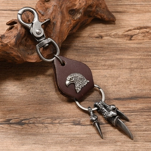 Close-up of eagle claw and head charms on vintage leather punk keychain pendant