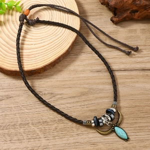 Macro detail of Bohemian turquoise pendant with braided brown PU leather and metal beads