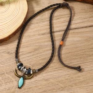 Detail of western turquoise pendant on brown leather cord with ethnic style beads
