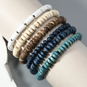 Detail of five bohemian style handmade wood bead bracelets on a cylindrical display