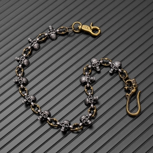 Macro shot of punk wallet chain featuring silver skull charms and horseshoe metal links