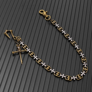Détail de chaîne de pantalon gothique avec pendentif crâne et maillons de croix bicolores