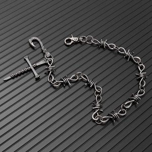 Détail du pendentif croix gothique tête de mort sur une chaîne de taille style barbelé