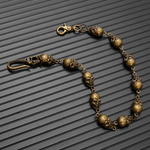 Detail of gothic punk bronze skull chain with metallic hooks for jeans and belts