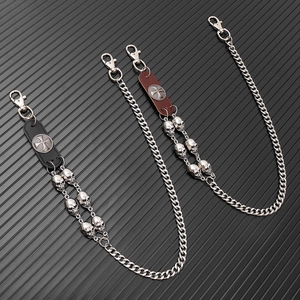 Punk style leather wallet chains with silver skull charms and cross snaps on black background