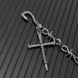 Détail du pendentif croix crâne gothique et chaîne en fil barbelé avec boucle gravée