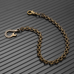 Detail of vintage brass punk wallet chain with hexagonal links and heavy lobster clasp