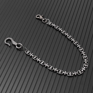Macro detail of Gothic punk trousers chain with vintage cross links and carved S-hook