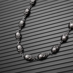 Detail of gothic punk trouser chain with vintage skull charms and industrial link design