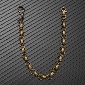 Detail view of retro bronze skull links and lobster clasp on dark punk style wallet chain