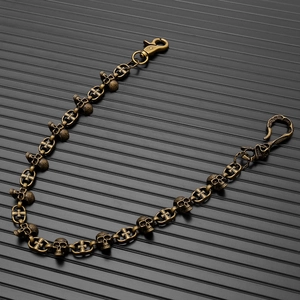 Dettaglio della catena da pantaloni punk in bronzo vintage con teschi e croci e ganci