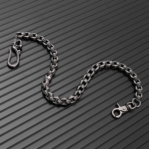 Detailed macro view of vintage skull links and swivel lobster clasp on punk chain