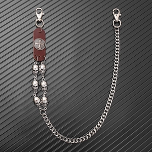 Detail of punk trousers chain featuring silver skulls and leather cross medal