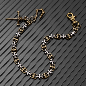 Détail de chaîne de pantalon punk vintage avec croix bicolores et pendentif crâne