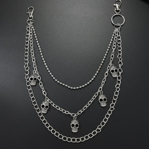 Detail view of multi-layer punk waist chain featuring five metallic skull pendants