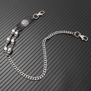Detailed punk style chain featuring silver skulls and cross emblem on black leather