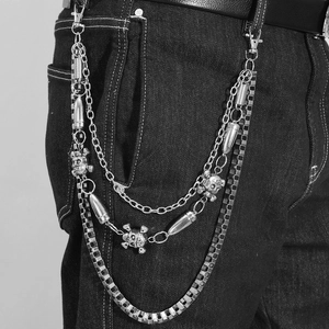 Three-layer punk skull wallet chain with bullet pendants on black denim trousers