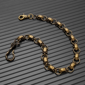 Detailed macro view of vintage bronze skull link chain with lobster clasp and hook closure