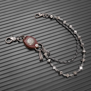 Detail of punk hip-hop wallet chain with metal dice charms and brown leather accent