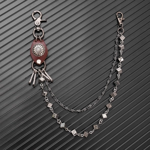 Detail of double punk waist chain featuring metal dice pendants and vintage leather accents