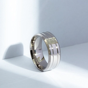 Detail of matte black titanium steel ring showing parallel grooves and polished mirror finish