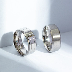 Detail of matte brushed and polished black titanium rings for men with grooved edges