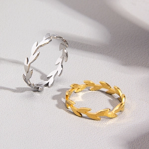 Makroaufnahme von Olivenzweig-Ringen in Silber und Gold mit feiner Metallstruktur
