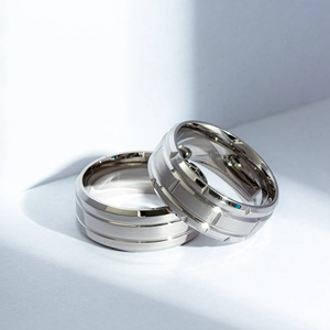 Detail of matte black and silver titanium rings with brushed finish and industrial grooves