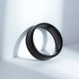 Macro shot of matte black titanium ring for men with parallel grooves and industrial style