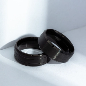 Close-up of matte brushed and polished grooved textures on black titanium rings