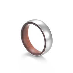 Détail macro d'une bague en titane brossé argenté avec incrustation en bois brun rouge