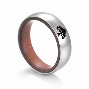 Gros plan d'une bague en titane avec intérieur en palissandre et motif de silhouette d'arbre