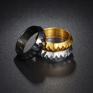 Macro of stacked punk titanium steel rings with textured geometric pyramid facets