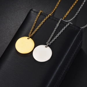 Minimalist round disc necklaces in gold and silver steel on black jewelry case