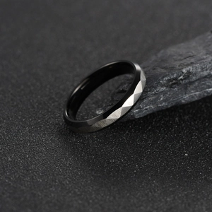 Black brushed titanium steel ring with geometric faceted edges and industrial design