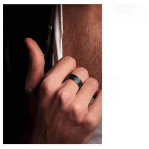 Close-up of 8mm matte black titanium steel ring for men with minimalist brushed finish